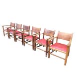 A set of six arts and crafts oak dining chairs with deep panelled backs and tapering platform arms