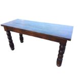 A solid oak dining table with thick top raised on bulbous turned legs. (60.25in x 23.25in x 30.5in)