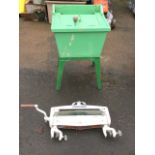 An old painted washing machine, the tapering wood frame around a galvanised tub having crank handle,