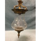 A gilt metal hanging hall lantern with bulbous glass shade having scrolled mounts, supported by
