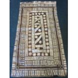 A handmade paper(?) African wallhanging, decorated with batik style geometric bands and