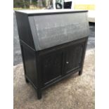 An ebonised bureau with fallfront enclosing an interior with shelves and open compartment, above a