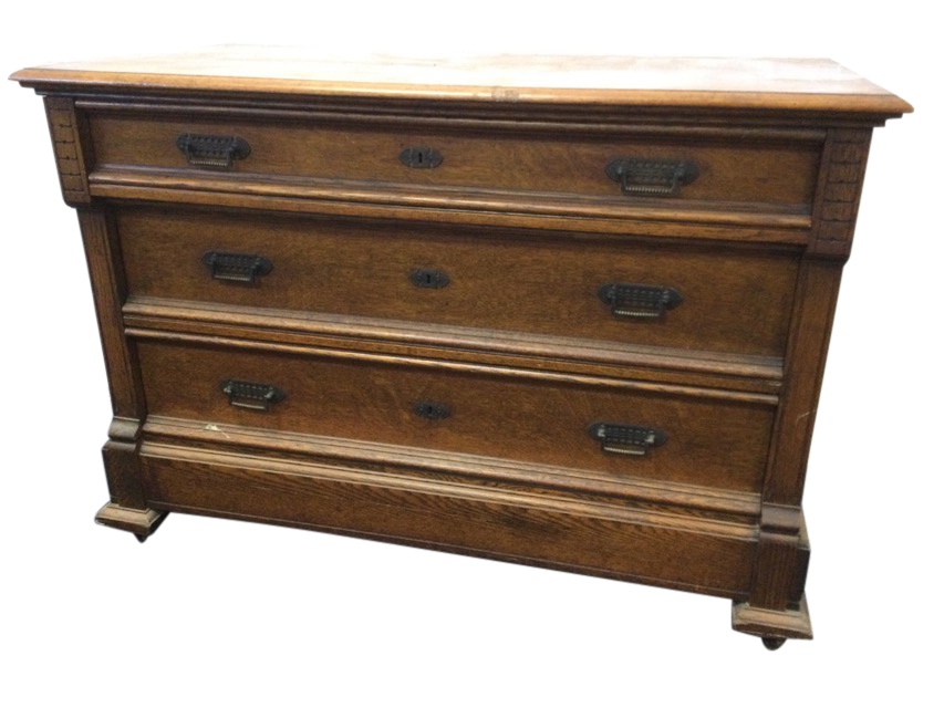 A European oak chest of three graduated panelled drawers mounted with brass handles framed by