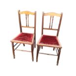 A pair of late Victorian mahogany bedroom chairs with arched back rails on twin spindles above