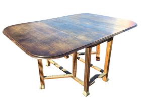 A C20th oak dining table with rule-jointed rounded drop leaves supported by gates, raised on