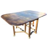 A C20th oak dining table with rule-jointed rounded drop leaves supported by gates, raised on