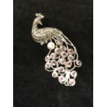 A 925 silver peacock brooch, the bird set with marcasites to body having rubies to openwork