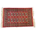 A small Tekke style Turkish rug woven with fourteen oval medallions on madder field framed by