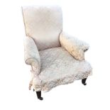 An Edwardian upholstered armchair in pink damask having rectangular back and long sprung seat with
