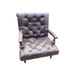 A leather button upholstered armchair, the wide brass studded seat having armrests on fluted