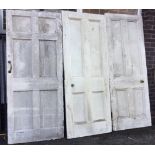 A pair of Victorian painted four-panel doors; and a slim six-panelled door - also painted. (3)