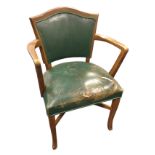 A mahogany chair with leather upholstery having arched shield back and shaped arms above a sprung