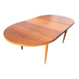 A G-plan teak dining table with rounded ends and integral spare leaf, raised on turned tapering