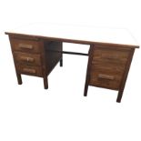 An oak office desk with two pedestals of drawers beneath slides flanking a kneehole, raised on