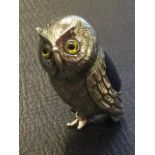 A sterling silver owl pin cushion, the bird inset with glass eyes with soft panel to back -