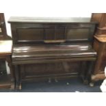 An Elysian upright piano in stained panelled case having seven octave keyboard on shaped supports,