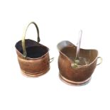 A near pair of copper helmet shaped coal skuttles on circular moulded bases with swing handles. (2)