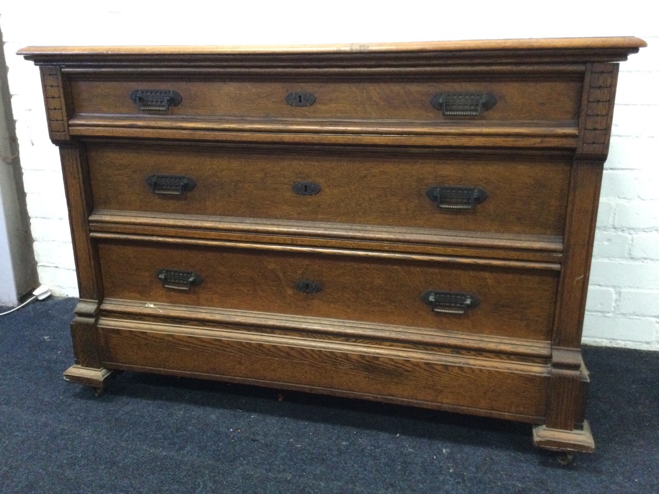 A European oak chest of three graduated panelled drawers mounted with brass handles framed by - Image 3 of 3