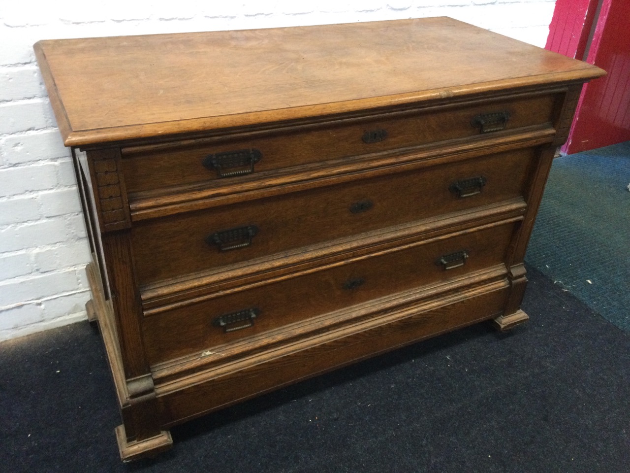 A European oak chest of three graduated panelled drawers mounted with brass handles framed by - Image 2 of 3