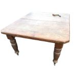 A Victorian telescopic oak dining table, the moulded canted top supported on fluted turned