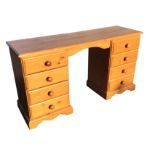 A pine kneehole dressing table or desk, with rectangular moulded top on two pedestals, each with