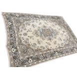 An Axminster style rug woven with floral medallion on pale ivory coloured field, framed by floral