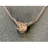 An 18ct white gold diamond pendant, the circular claw set stone of approx 0.4 carats, on a cage