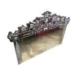 A rectangular Italian mirror, the plate framed by bevelled panels with cut floral decoration,
