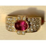 An 18ct yellow gold ruby and diamond cocktail ring, the bezel set oval ruby of over 0.8 carats