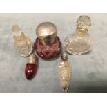 A small cranberry glass bullet shaped scent bottle with hallmarked silver screw cover; a nodule