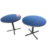 A pair of modern circular tables raised on metal columns with four platform feet. (35.25in x