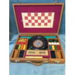 A cased games compendium with roulette wheel, chess, cribbage, draughts, dominoes, etc. the set with