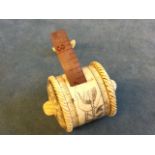 A bobbin shaped 19th century style carved bone sewing tape measure with engraved penwork