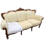 A Louis Quaize style three-seater sofa, the upholstered back with pierced carved frame above studded