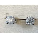 A pair of 18ct white gold diamond stud earrings, the brilliant cut claw set stones of over one