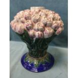 A large majolica tulip vase modelled as a rope-bound bunch of flowers, on leaf moulded circular