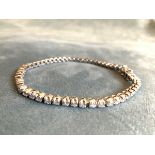 An 18ct white gold diamond tennis bracelet, set with fifty-four claw set hinged diamonds weighing