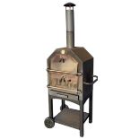 An outside pizza oven on trolley stand, with tubular chimney above chambers with interior grills and
