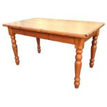 A reproduction pine kitchen table with rectangular moulded top on turned legs. (53.5in x 31.75in x