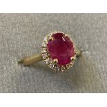 An 18ct yellow gold ruby and diamond cluster ring, the oval claw set ruby weighing three carats, the