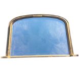 A Victorian gilded overmantle mirror with cushion moulded arched frame on moulded plinth, having