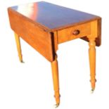 A Victorian satin birch drop-leaf table with rounded leaves supported on hinged brackets, having