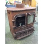 A cast iron stove with back boiler, the rectangular rounded top above two doors, having vented ash