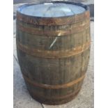An oak whiskey barrel, the staves bound by six riveted metal strap bands. (34.5in)