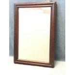 A rectangular Edwardian mirror in cushion moulded stained frame. (21.5in x 14.75in)