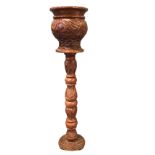 A carved hardwood jardiniere on stand, with leaf carved column supporting a vase with conforming