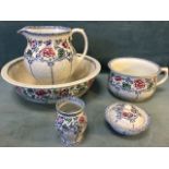 A Maling five-piece wash set decorated with floral friezes above scroll framed panels with jug &