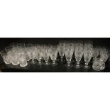 A suite of cut glass with ribbed bodies beneath hobnail bands, with four sizes of glasses, and