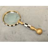 A brass library magnifying glass, the rim and handle inlaid with chequered bone panels, the shaft