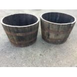 A pair of oak barrel planters, the staves each bound by three riveted metal strap bands. (25.5in x